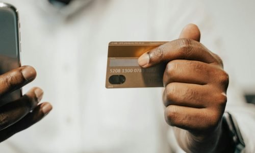 Person using a smartphone and credit card for online shopping or payment.