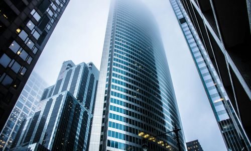 Dramatic view of modern skyscrapers shrouded in fog in an urban cityscape.
